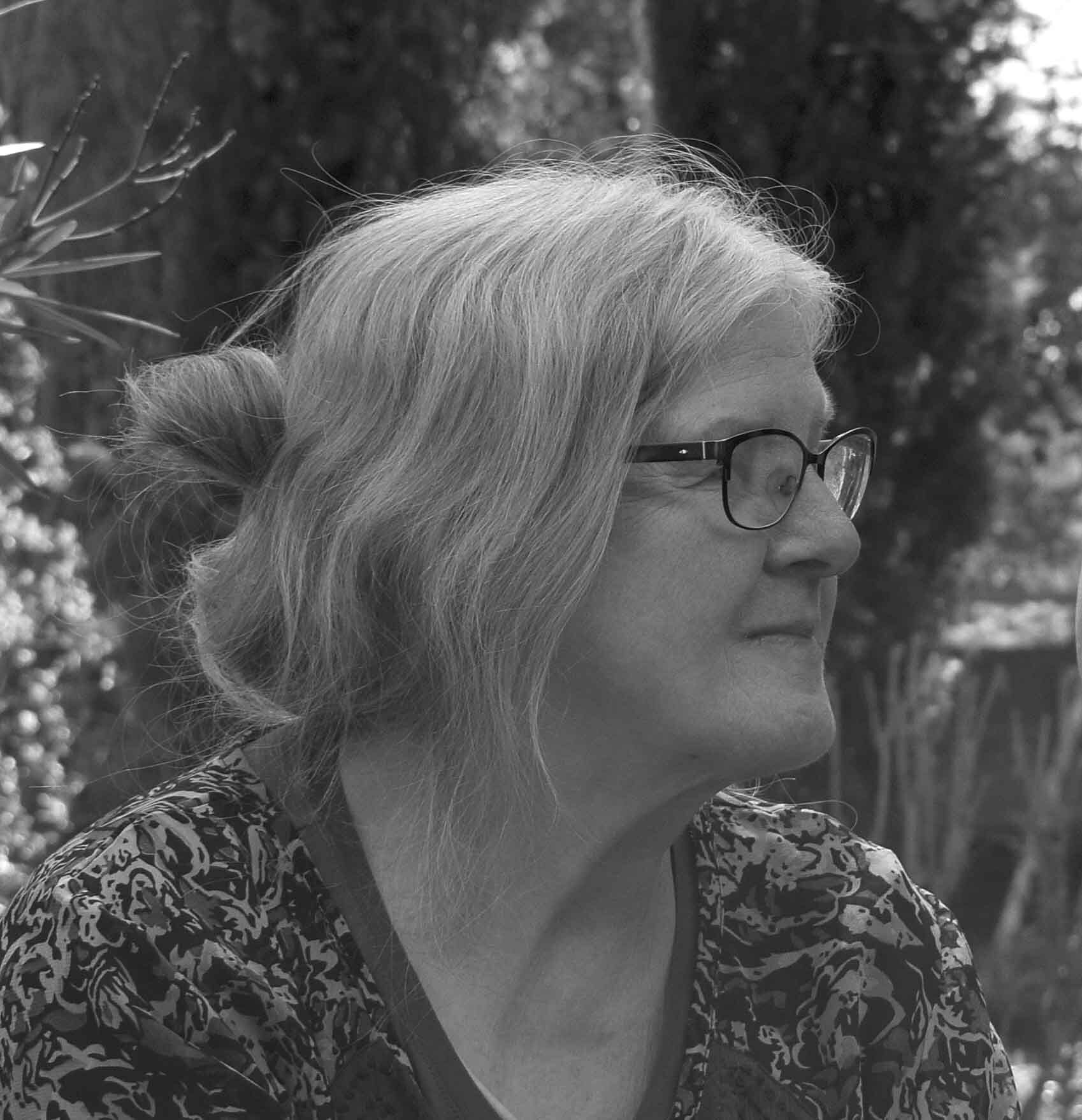 Schwarz-Weiß-Foto der Künstlerin Renate U. Schürmeyer, sie trägt eine Brille und lange Haare, die von einer Klammer im Nacken zusammen gehalten werden